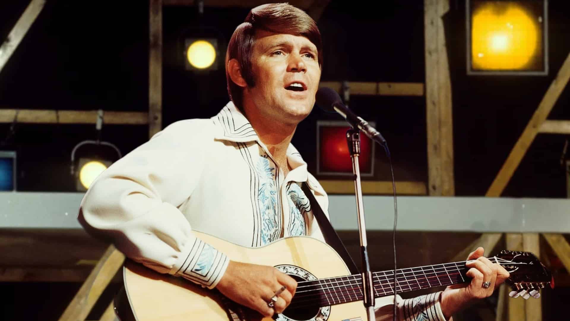 Glen Campbell performing with his guitar in the 1970s, singing the hit song “Rhinestone Cowboy” that became his signature classic.