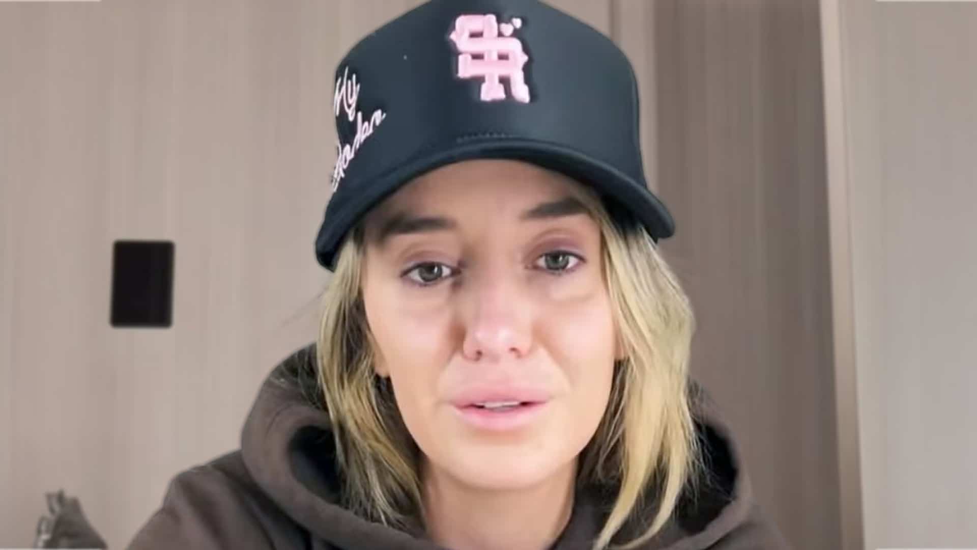 Lainey Wilson appears emotional in a video message after canceling her Houston show due to worsening voice issues.