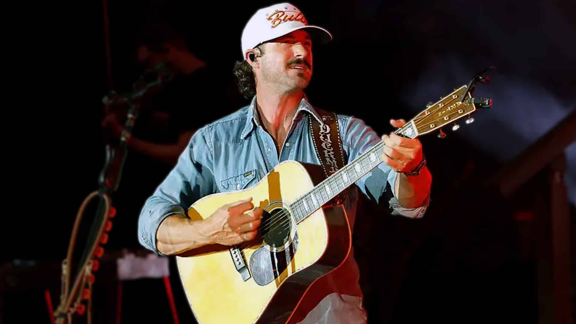 Country singer Riley Green plays guitar in concert, reflecting on his journey from a construction worker to chart-topping Nashville star.