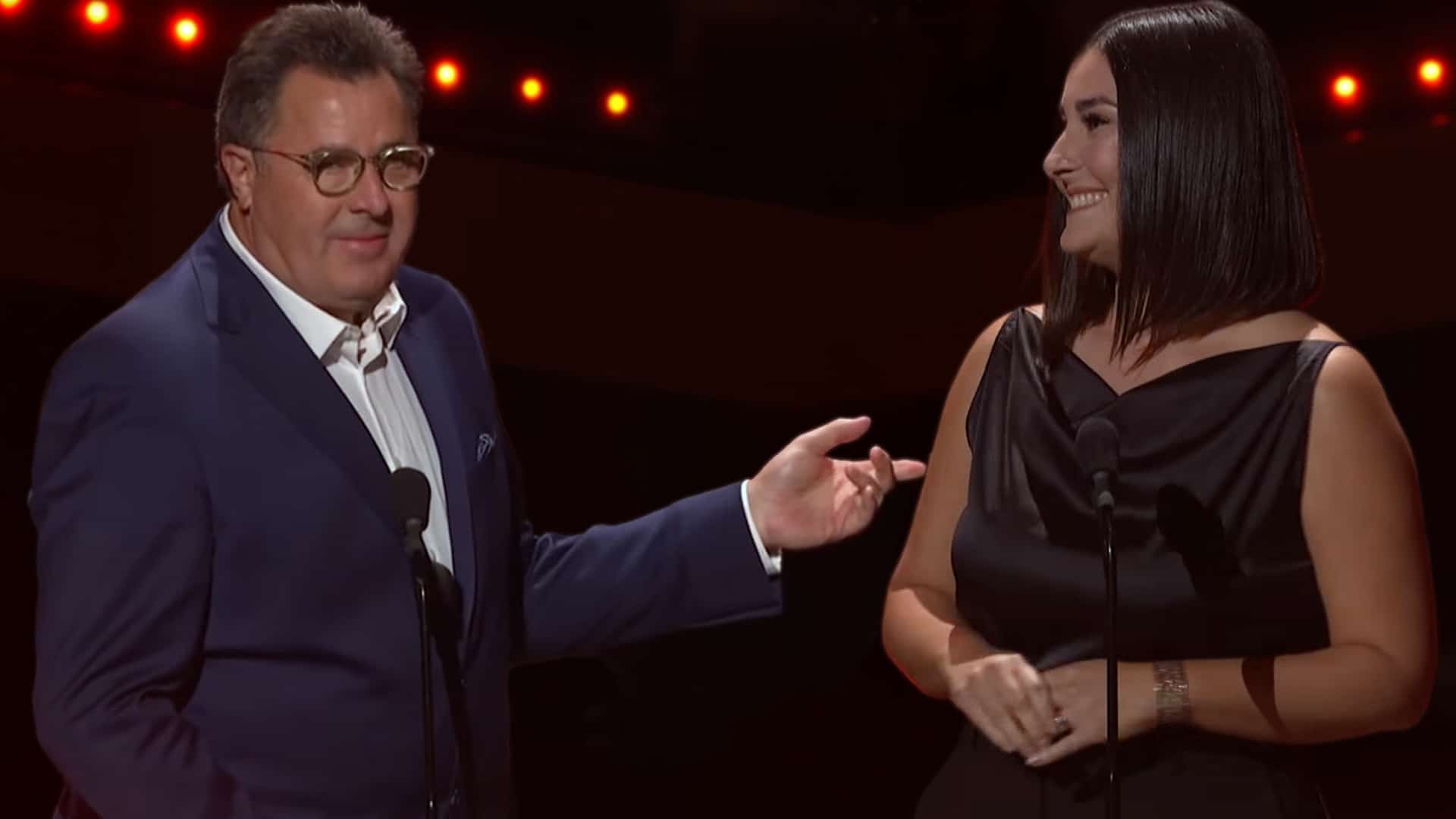 Vince Gill on stage with his daughter Jenny Gill as she recalls the story of him skipping his Opry debut for her school talent show.