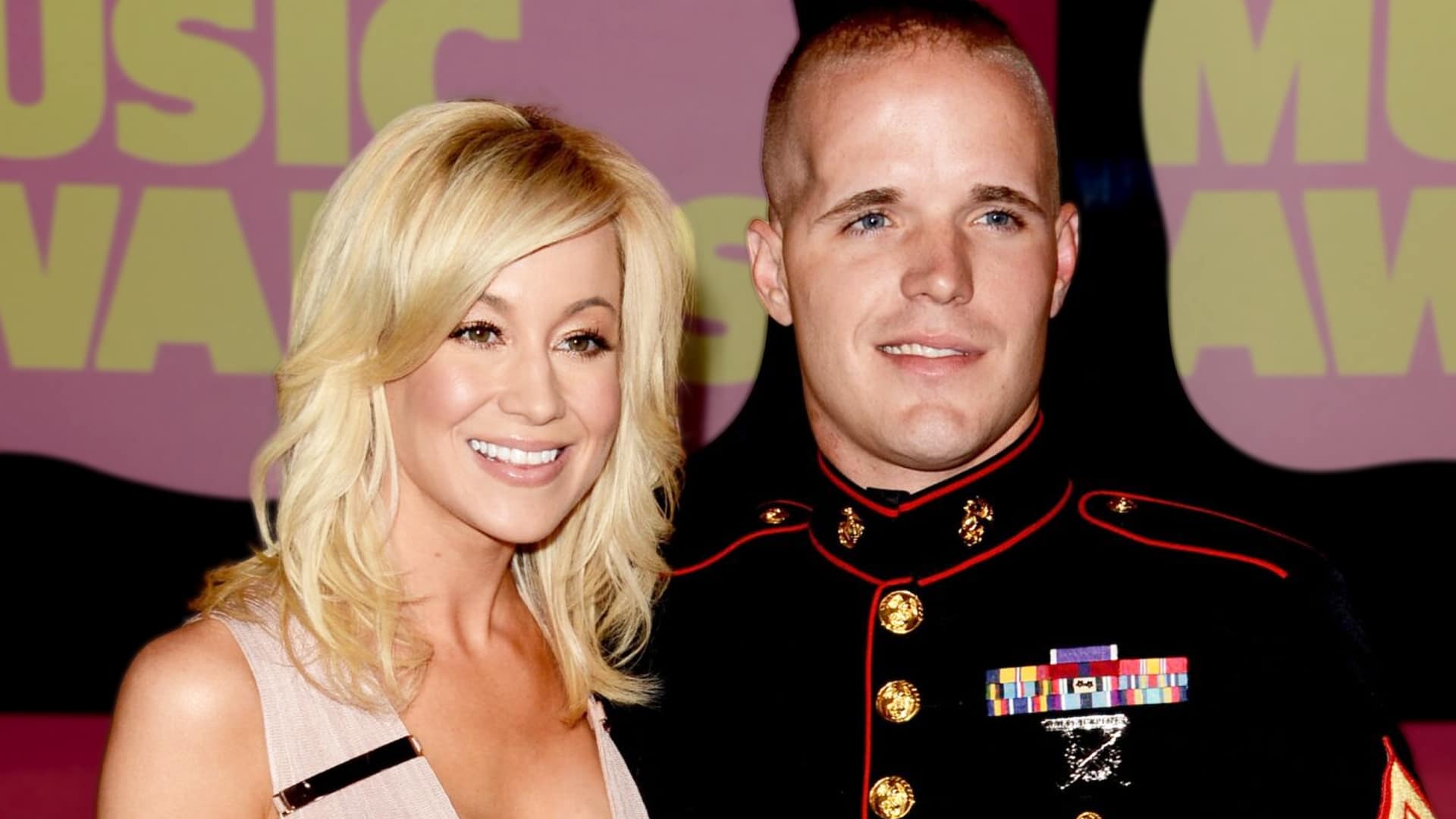Country singer Kellie Pickler posing with a man in dress blues at an awards show, amid reports of a judge dismissing a bizarre poisoning lawsuit against her.