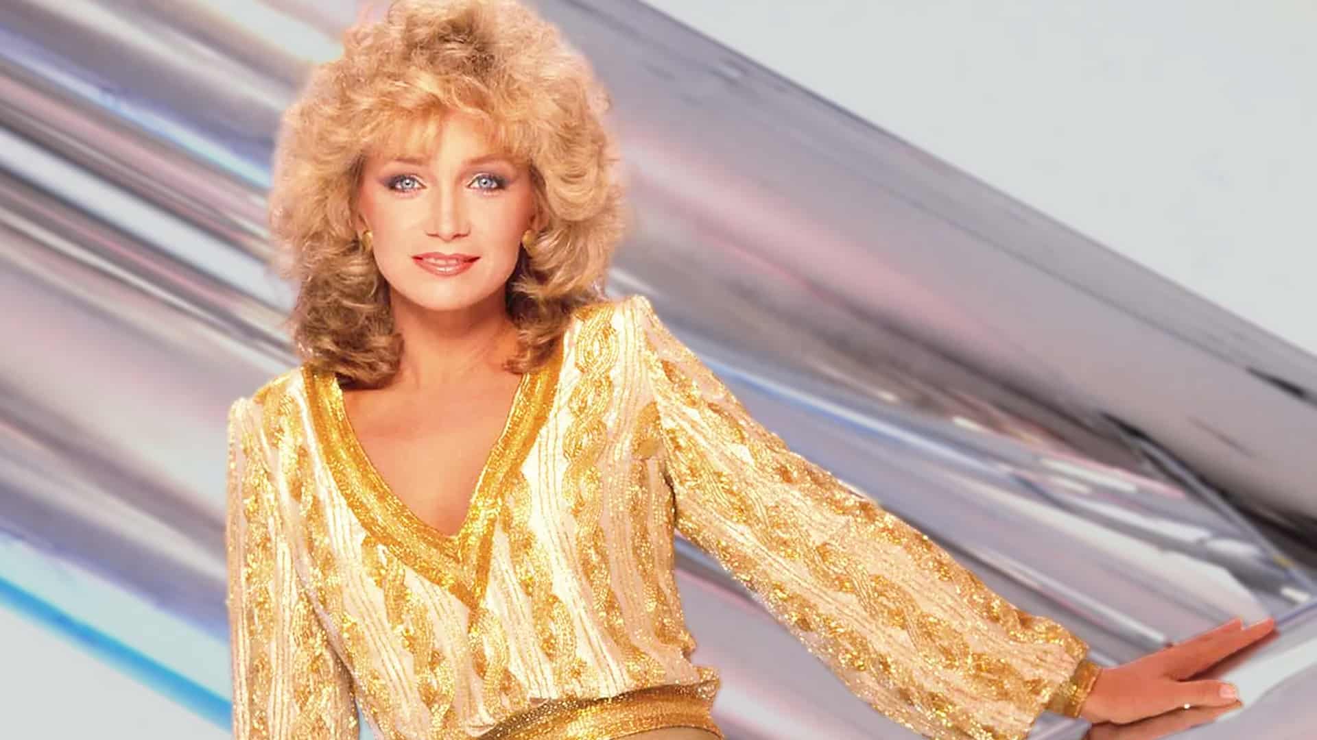 Barbara Mandrell in a shimmering gold outfit, capturing the timeless elegance of the country icon who chose to step away at the height of her fame.