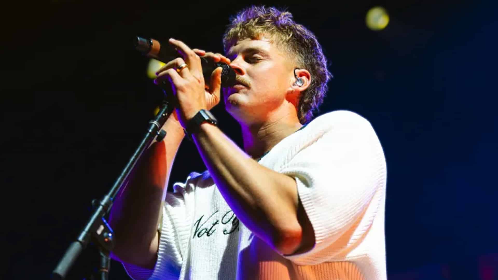 Forrest Frank singing passionately into a microphone, following his decision to skip major Christian music award shows, igniting discussion among fans and fellow artists.