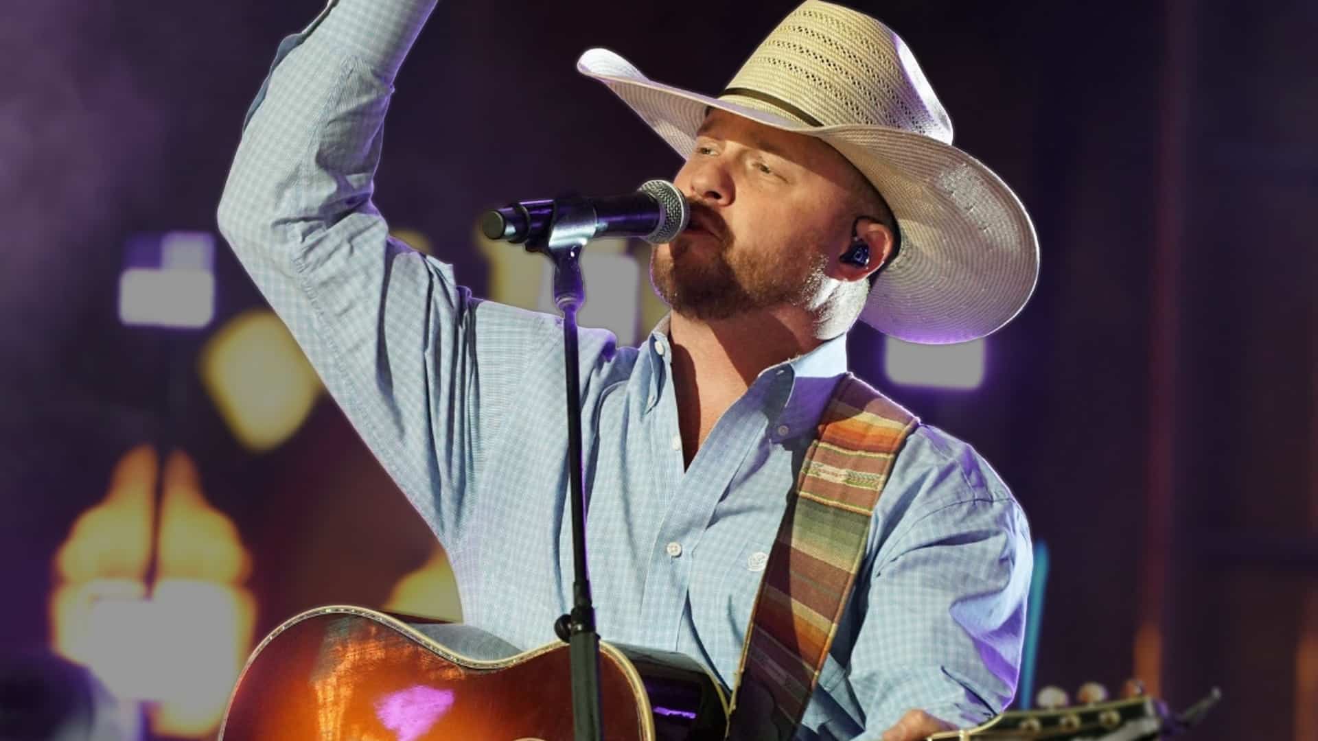 Cody Johnson performing onstage with his guitar and cowboy hat, as news of his surgery and 2025 tour cancellations leaves fans rallying behind him.