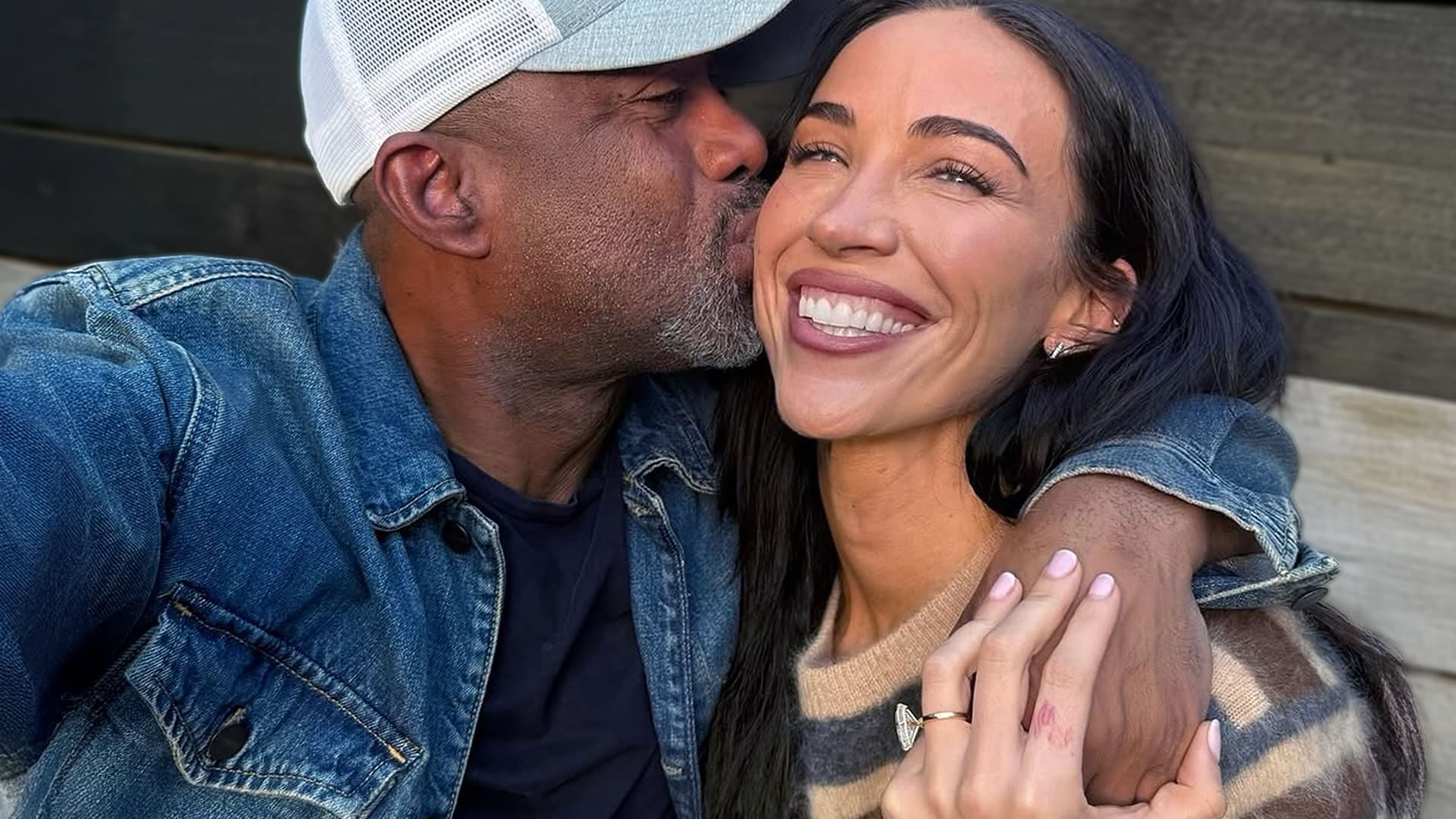 Country star Darius Rucker embracing Emily Deahl with a sweet kiss, celebrating their engagement and the love story fans can’t stop cheering for.