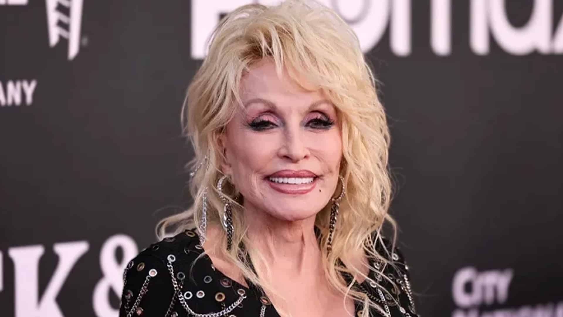 Dolly Parton smiling on the red carpet in a black studded outfit, as her sister reassures fans the country icon is simply resting and recovering.