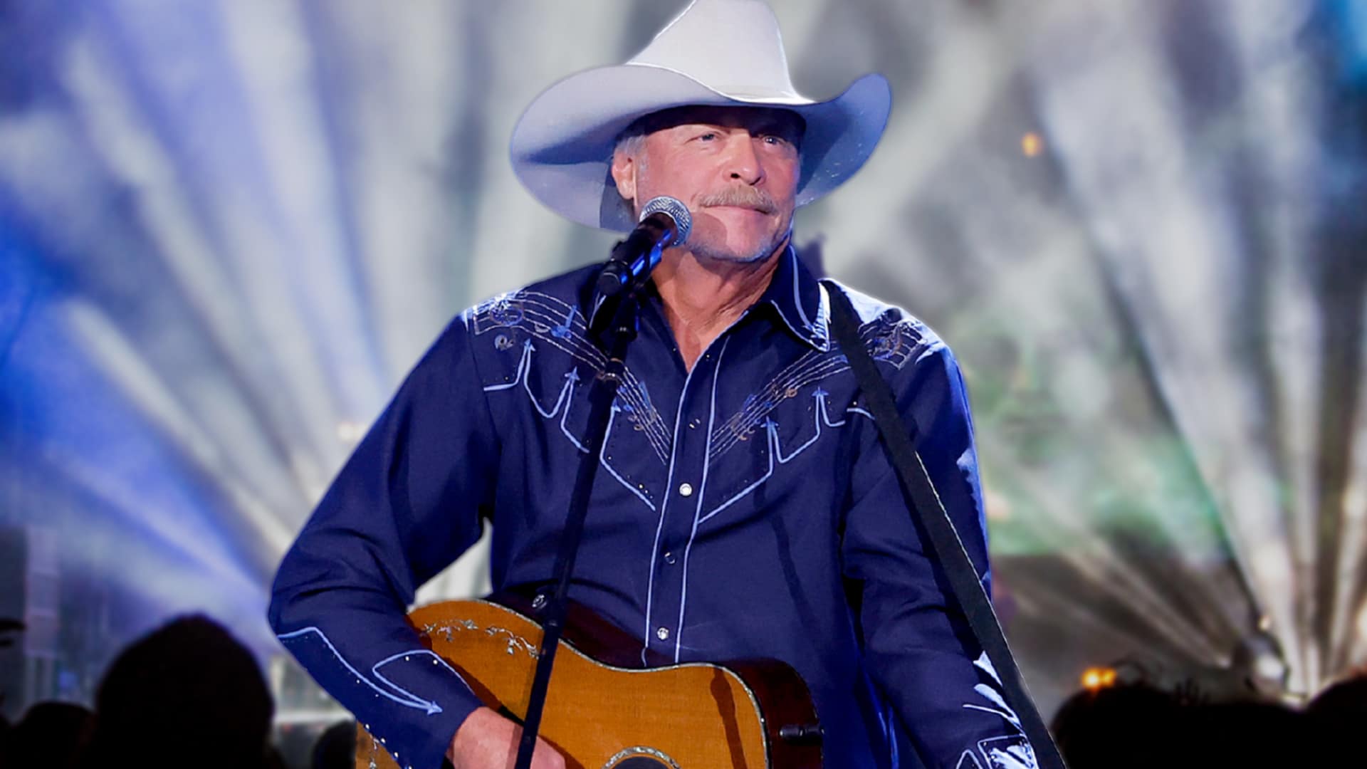Alan Jackson tipping his cowboy hat onstage with his guitar, as fans express outrage over long waits and soaring ticket prices for his final show.