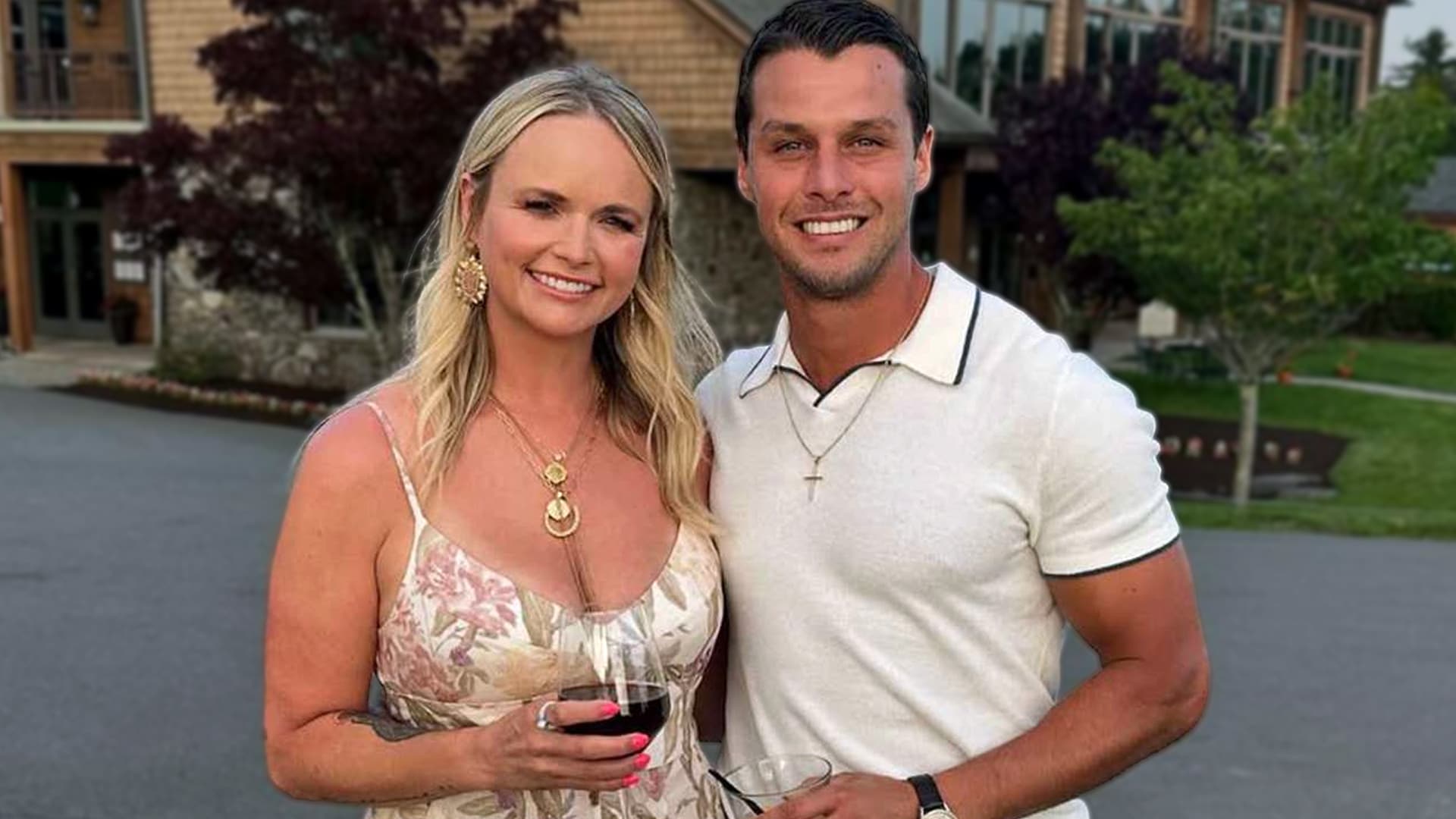 Miranda Lambert and her husband Brendan McLoughlin smiling together outdoors with wine glasses in hand, celebrating his full embrace of country life.
