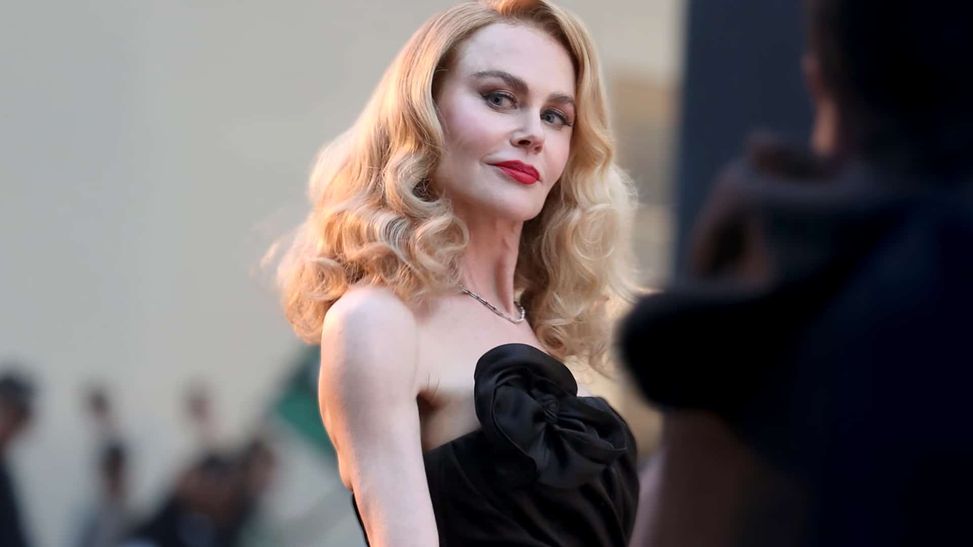 Nicole Kidman posing in a strapless black Chanel gown with vintage curls and red lipstick, exuding Hollywood glamour after her recent split from Keith Urban.