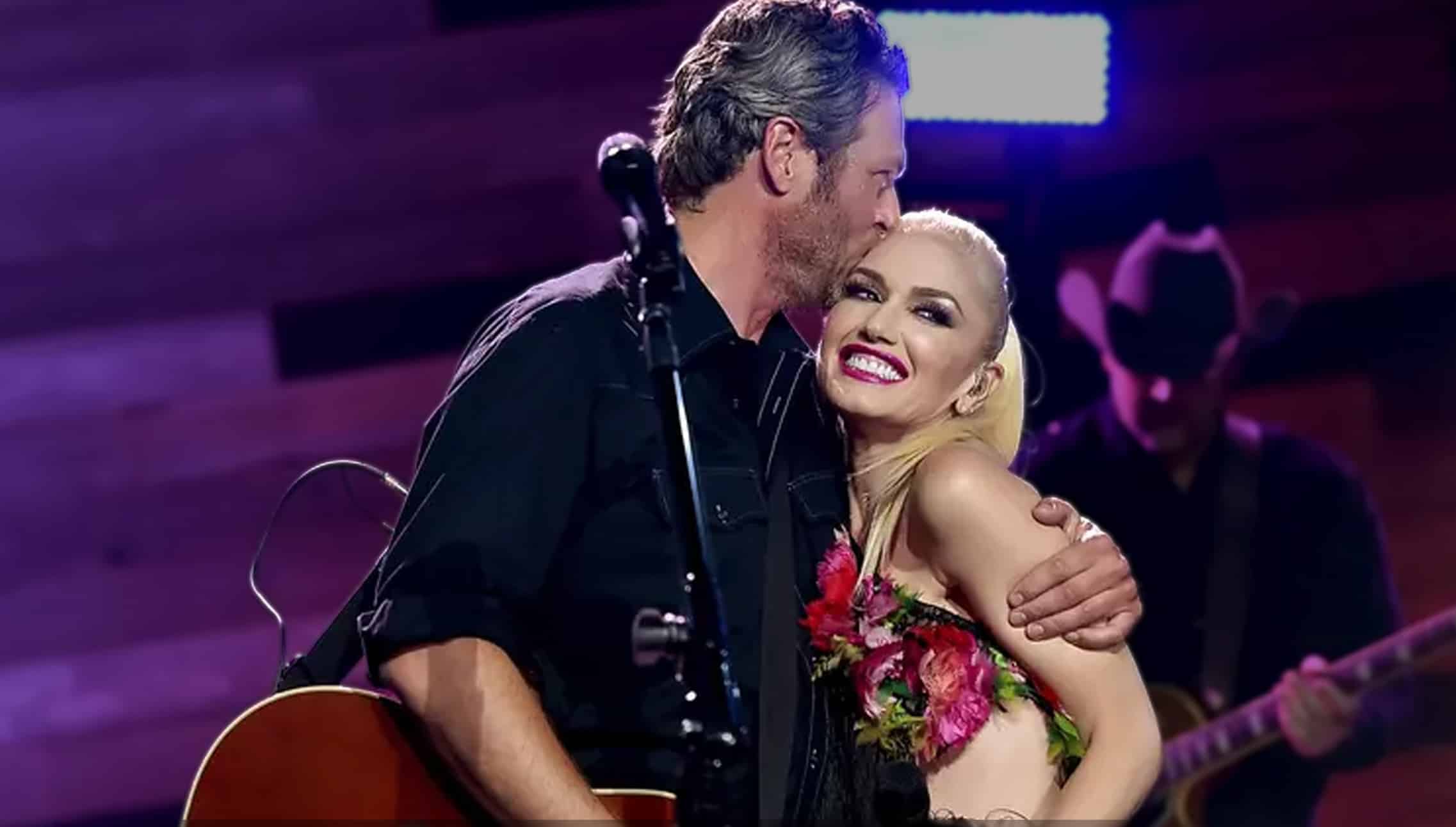 Blake Shelton kissing Gwen Stefani on the cheek during a live performance hug, smiling on stage moment that fuels hope amid divorce rumors as the couple plans quiet Oklahoma Christmas with her kids.