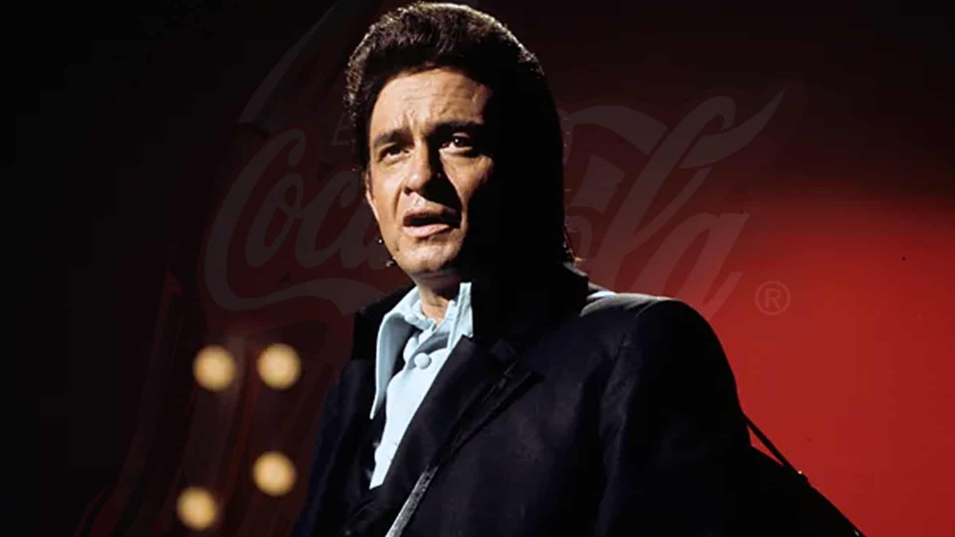 Classic photo of Johnny Cash in black suit under red lighting, at the center of a new lawsuit from his estate against Coca-Cola over unauthorized use of his voice under Tennessee’s ELVIS Act.