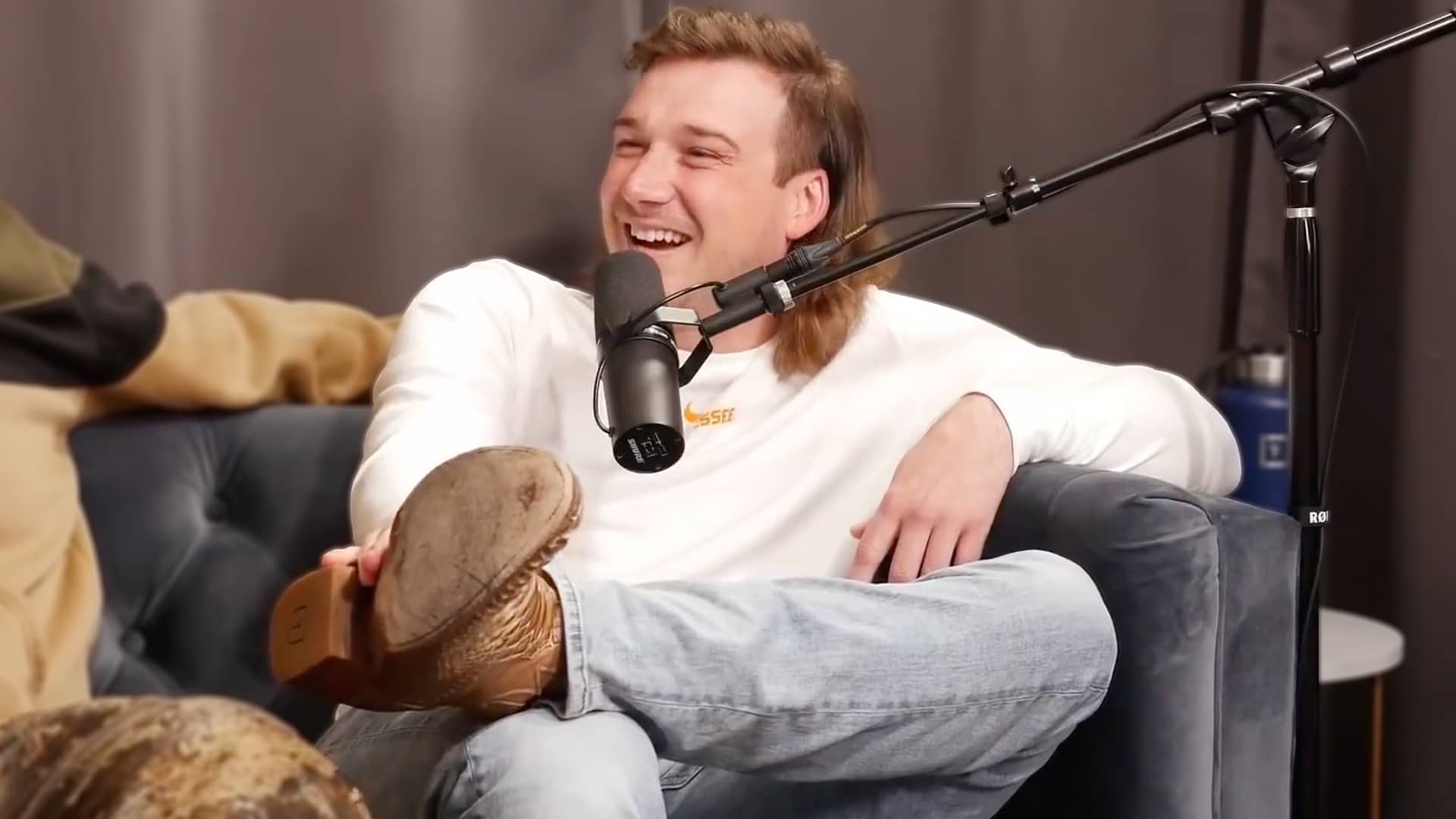 Morgan Wallen kicked back on a podcast couch, matching the laid-back vibe behind the small-town first-kiss story that stole the conversation.