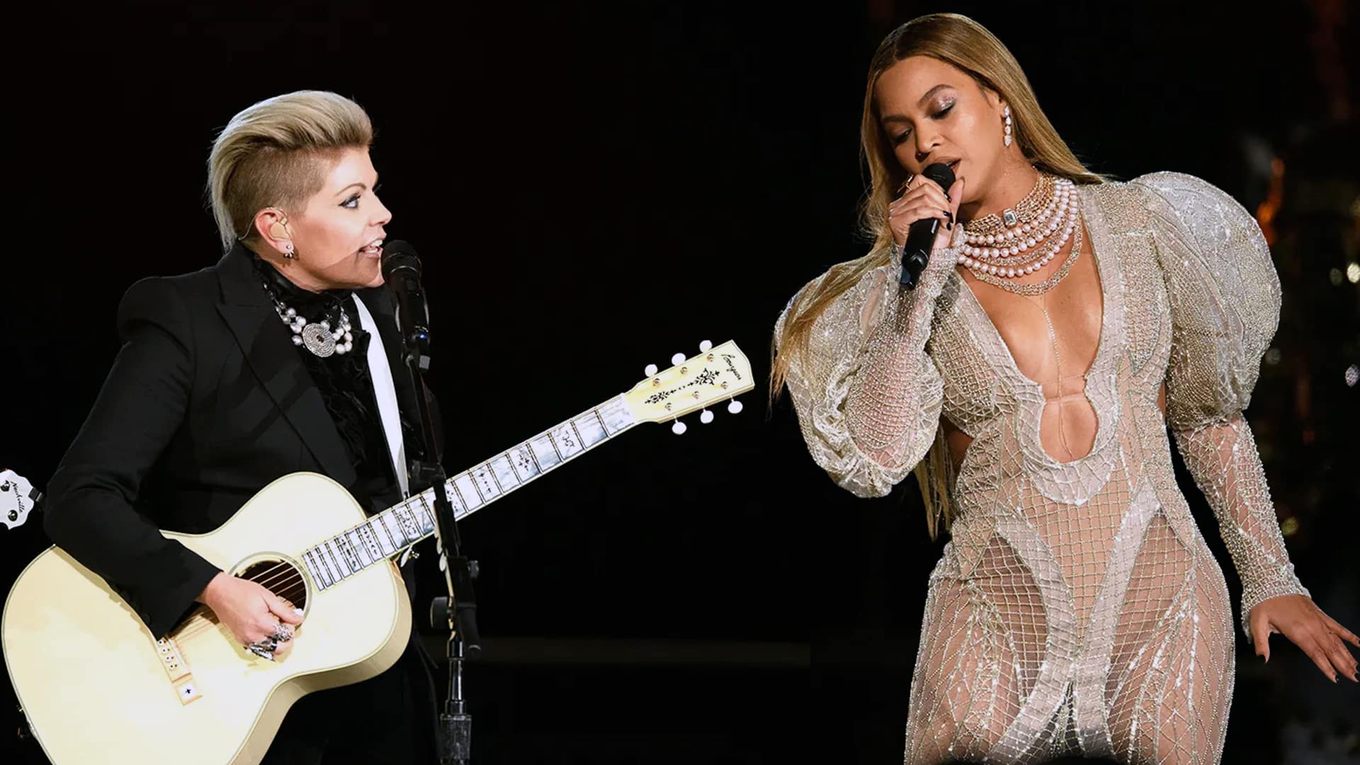Natalie Maines of The Chicks left playing guitar in black suit and Beyonce right singing in sheer beaded gown with pearls at 2016 CMA Awards performance that sparked massive backlash leading Natalie Maines to swear off future Country Music Association shows.