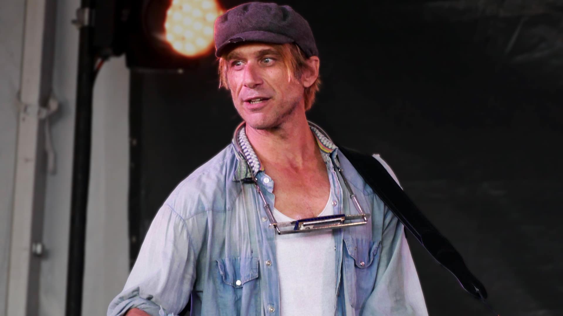 Todd Snider in a cap and denim shirt, capturing the wandering-poet spirit reflected in the alt-country tribute to his enduring songs.