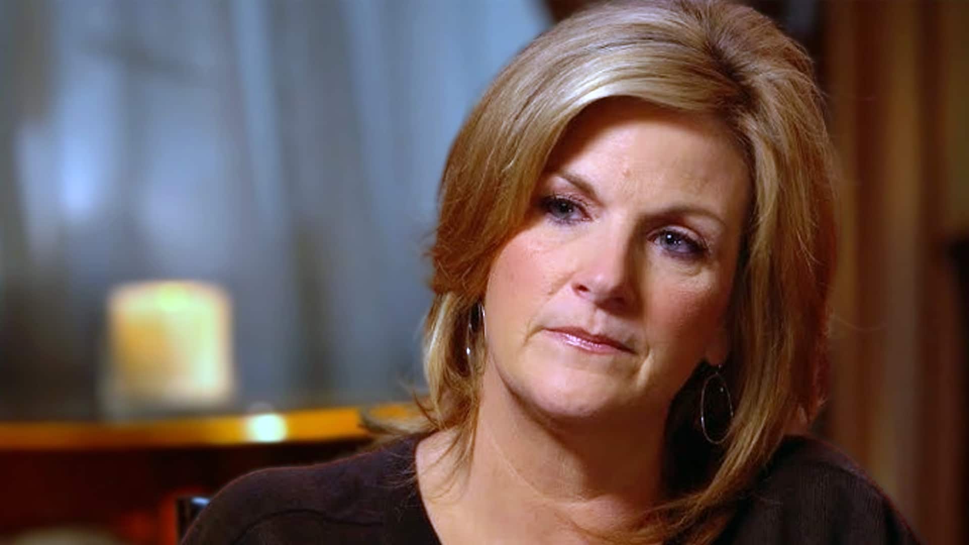 Trisha Yearwood sitting in a softly lit room, reflecting on the one question she wishes fans would stop asking with her trademark poise.