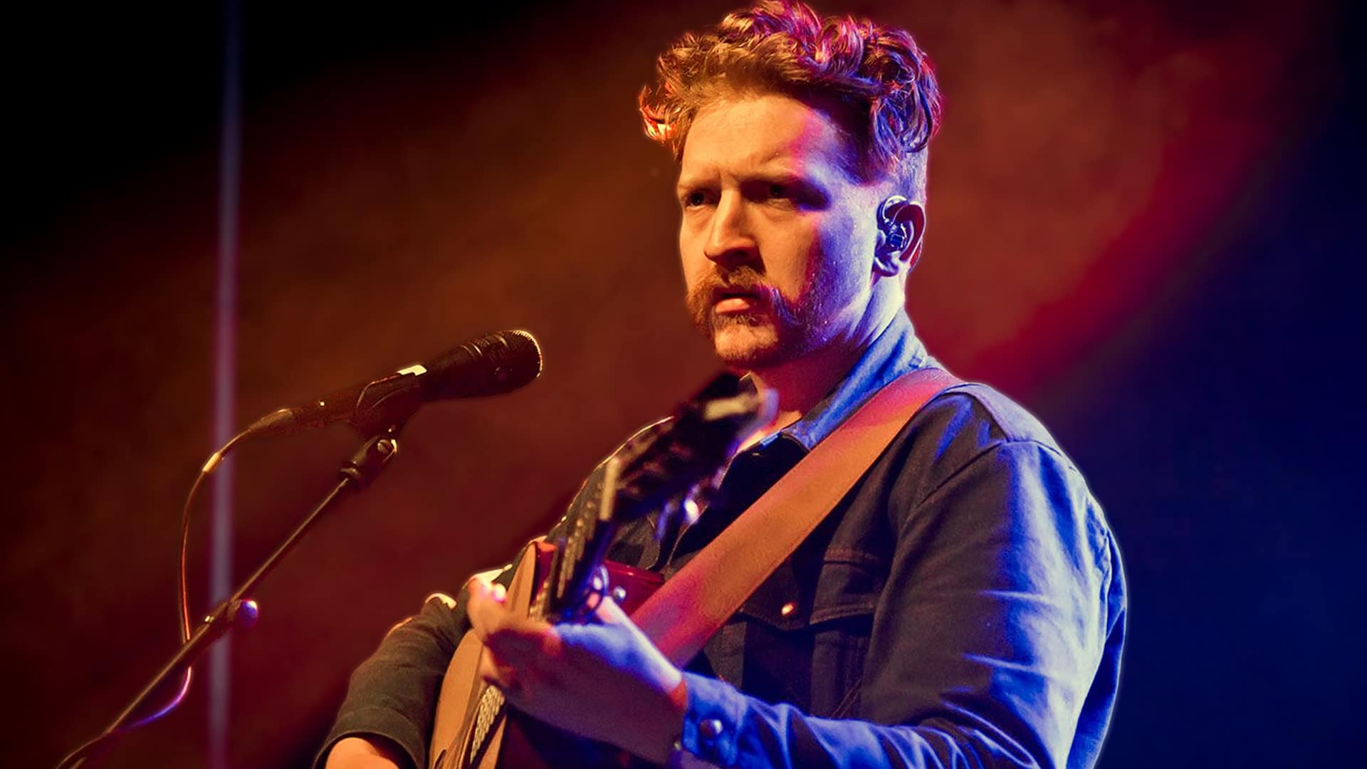 Tyler Childers performing with his guitar under warm stage lights, leading the 2026 country Grammy nominations with four nods.