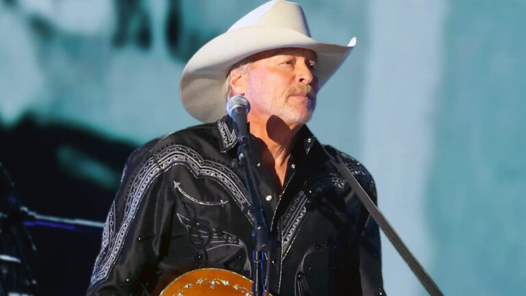 Alan Jackson, the $150 million net worth Country Music Hall of Famer, delivers an emotional farewell performance on stage with white hat, black western shirt, and acoustic guitar, marking the end of his touring career in 2025 for health reasons ahead of a 2026 Nashville finale.