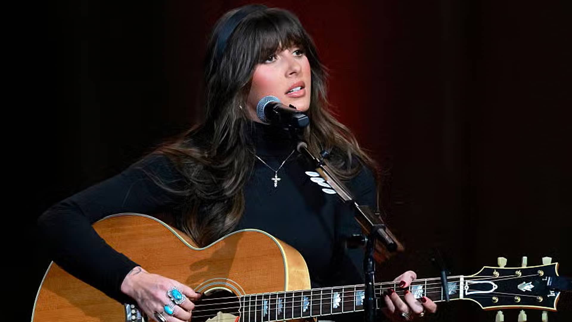 Ella Langley performs a heartfelt acoustic cover of George Strait's classic "Fool Hearted Memory," strumming guitar in a black turtleneck with cross necklace, delivering a raw and emotional tribute to the King of Country in 2025.