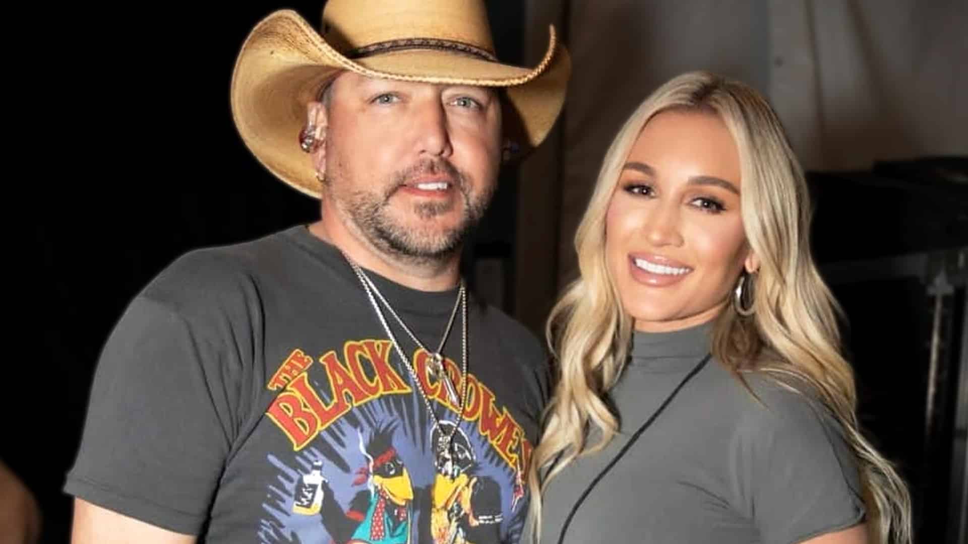 Jason Aldean and wife Brittany Aldean pose together smiling at Turning Point USA's AmericaFest in Phoenix, explaining why they remain unapologetic about their conservative beliefs and bold political stance despite backlash in 2025.