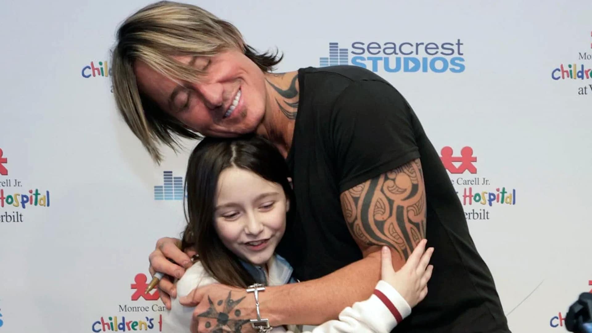 Keith Urban hugs a smiling young patient at Monroe Carell Jr. Children's Hospital in Nashville, spreading holiday joy with a heartfelt visit, gifting guitars and supporting music therapy for kids in 2025.