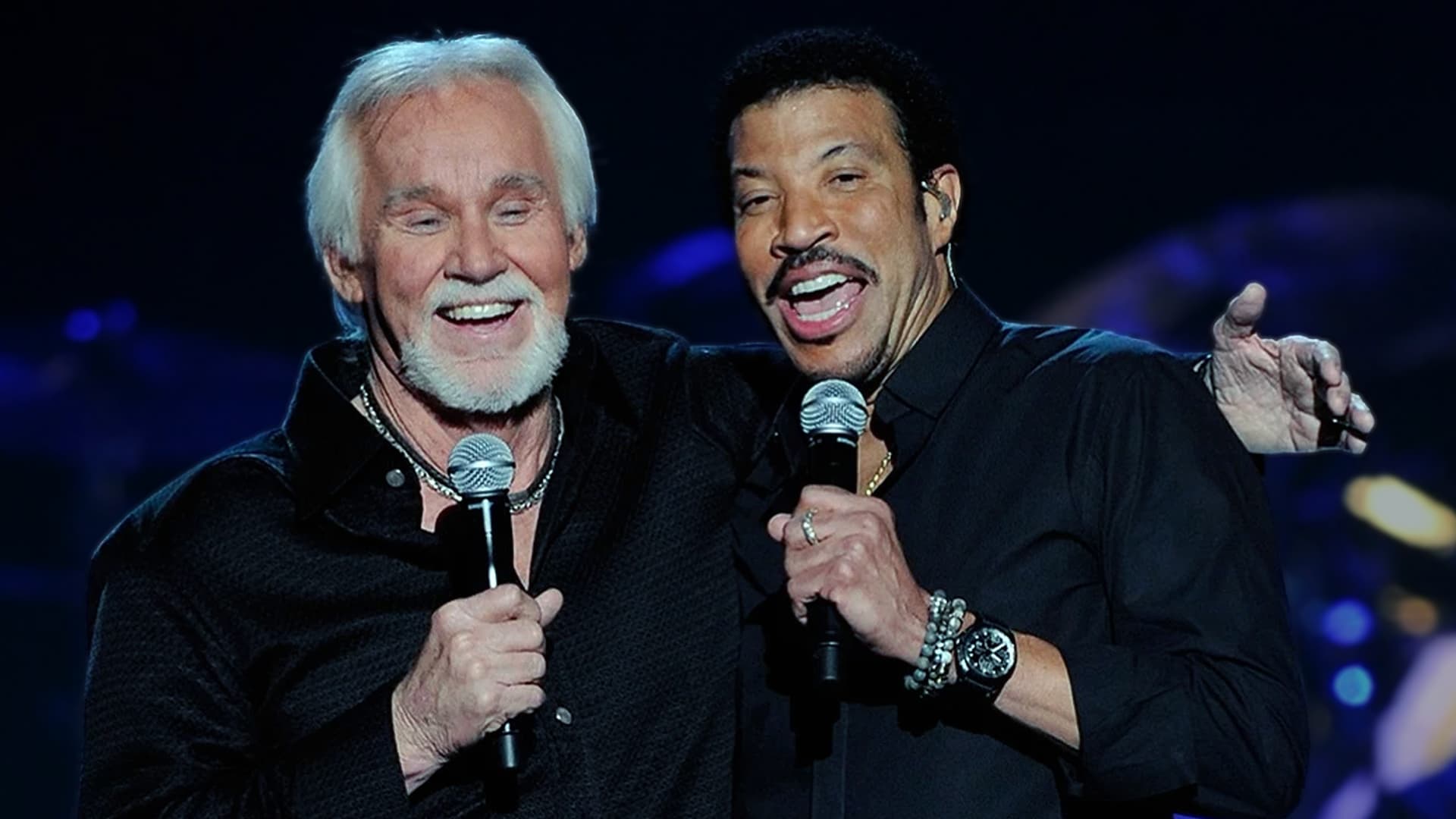 Kenny Rogers and Lionel Richie share the stage smiling with microphones in hand, celebrating the iconic 1980 hit "Lady" written by Lionel Richie in just five minutes, which topped the Billboard Hot 100, Country, and Adult Contemporary charts for Kenny Rogers.