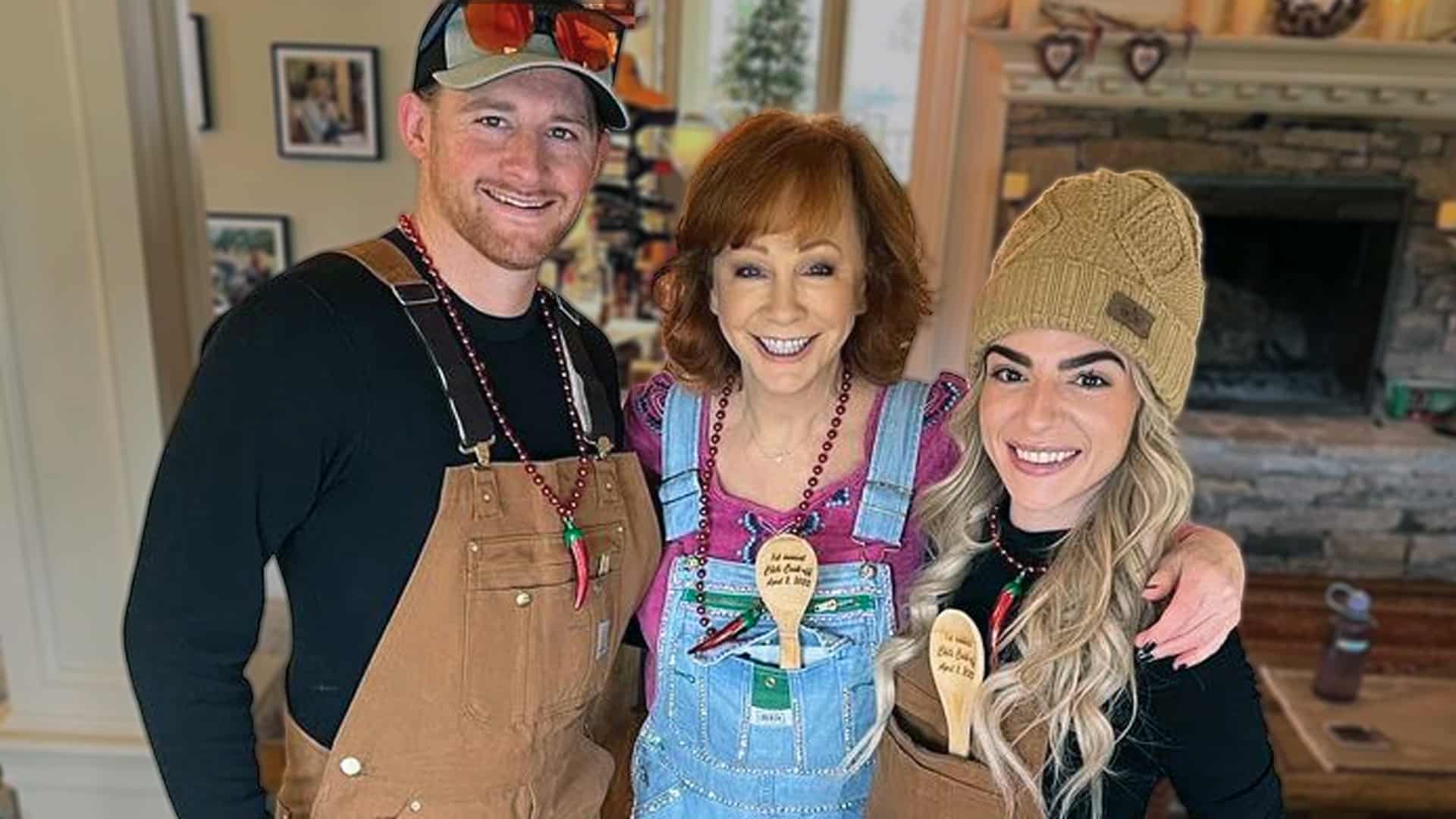 Reba McEntire with son Shelby Blackstock and daughter-in-law Marissa Branch smiling in festive overalls and chili-pepper necklaces at home, as Shelby opens up about the heartbreaking miscarriage of their long-awaited baby boy just months after losing Brandon Blackstock.