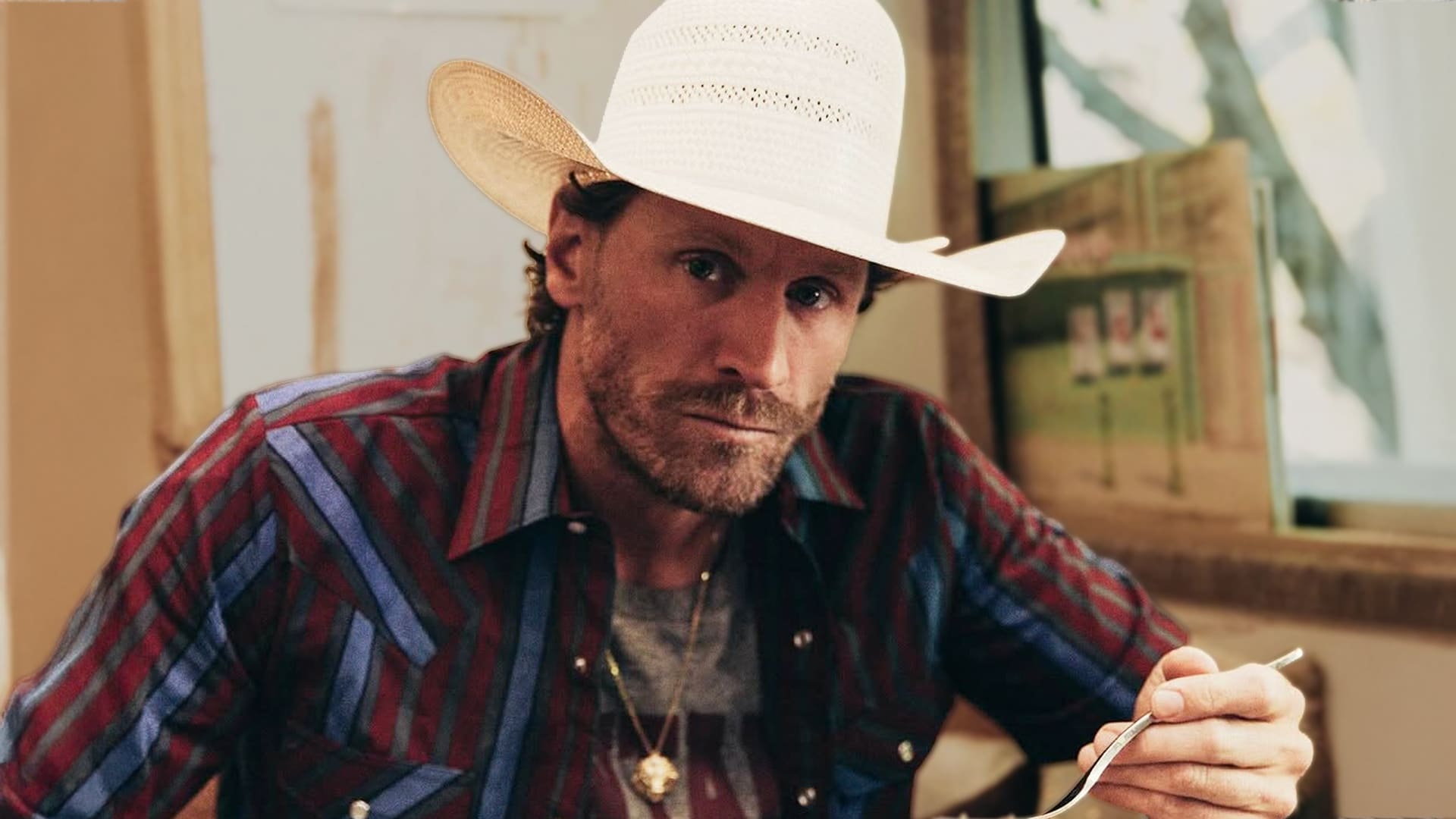 Chase Rice performs on stage in cowboy hat and striped shirt with suspenders, announcing in 2026 that he is taking his first break from touring after 13 nonstop years, admitting exhaustion and readiness to recharge for new music.