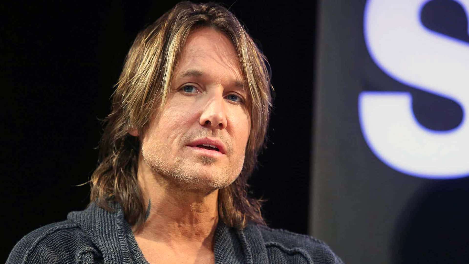 Keith Urban in dark sweater and long hair during an interview, as reports in early 2026 claim he regrets divorcing Nicole Kidman and wants reconciliation, while her friends worry she'll take him back after 19-year marriage ended.