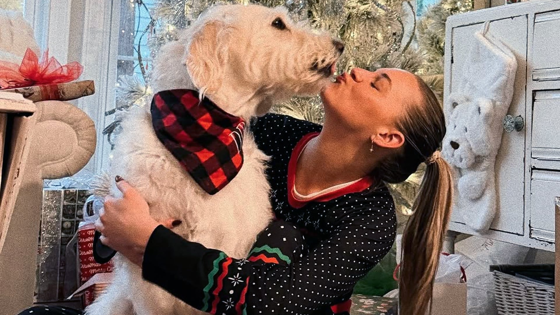 Kelsea Ballerini kisses her beloved dog Dibs on the nose in a sweet Christmas photo, both wearing festive outfits, as she mourns the loss of her soul dog after his year-long battle with cancer in heartfelt tribute.