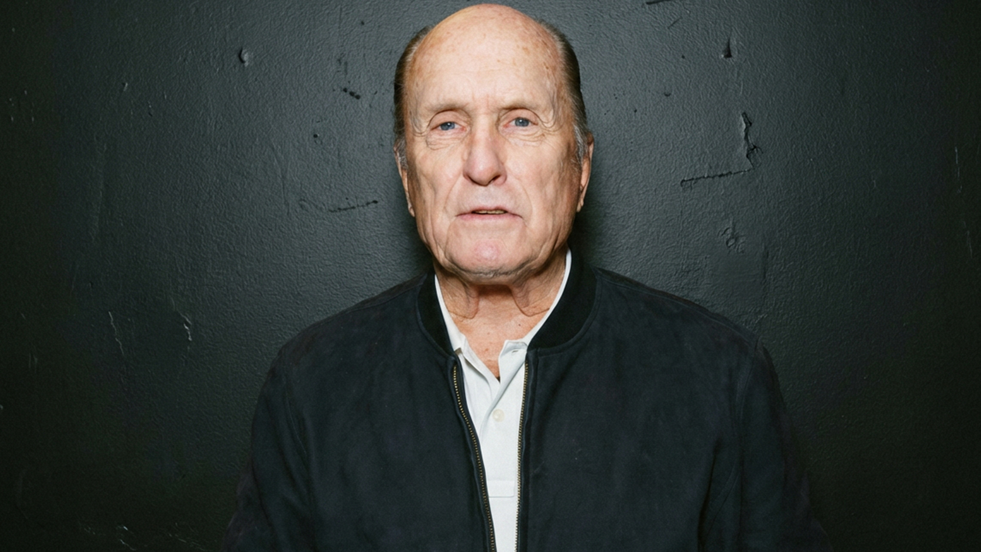 Robert Duvall, legendary Oscar-winning actor from The Godfather and Apocalypse Now, poses in black jacket holding marker in portrait photo following his death at 95 on February 15, 2026.
