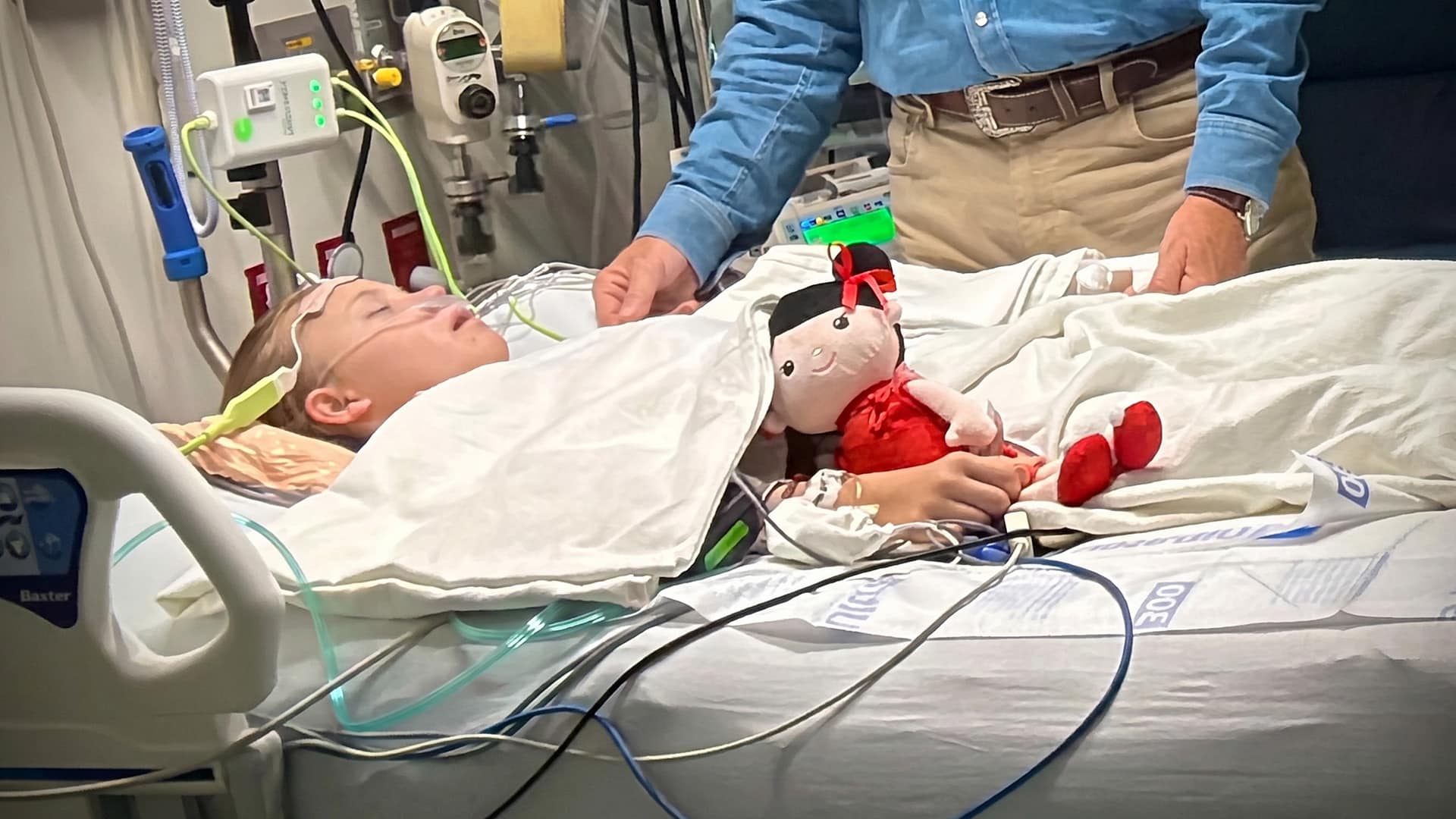 Rory Feek holding his daughter Indiana's hand in the ICU as she recovers after her successful open heart surgery.