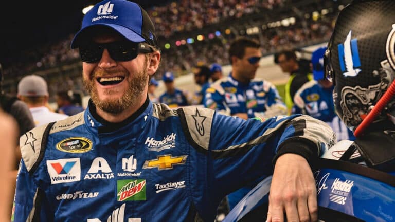 Dale Earnhardt Jr. is shown posing beside his racing car after dropping “Earnhardt” from the car and autograph while still calling Teresa very savvy.