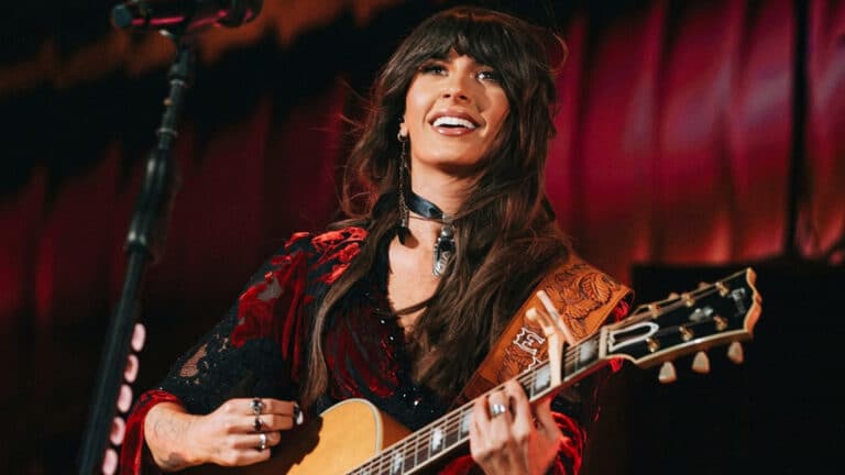 A photo of Ella Langley playing guitar on stage while she addresses the 2027 tour question during a livestream.
